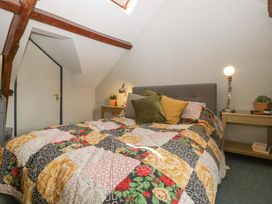 A bedroom with a bed and bedside table at Elm Cottage in Moreton-In-Marsh