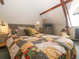 A bedroom with a bed and dresser at Elm Cottage in Moreton-In-Marsh