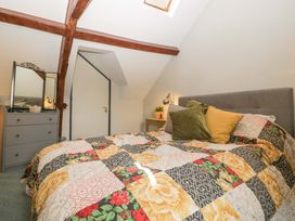 A bedroom with a bed and dresser at Elm Cottage in Moreton-In-Marsh
