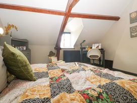 A bedroom with a bed and desk at Elm Cottage Moreton-In-Marsh