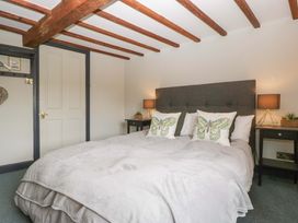 A bedroom with a bed and nightstands at Elm Cottage in Moreton-In-Marsh