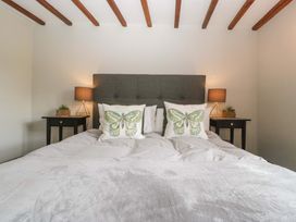A bedroom with a bed and bedside tables at Elm Cottage in Moreton-In-Marsh