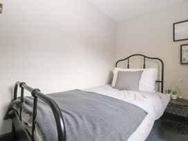 A bedroom with a bed and nightstand at Elm Cottage Moreton-In-Marsh