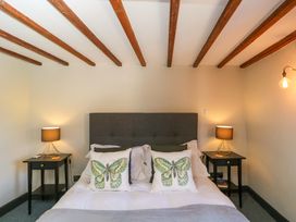 A bedroom with a bed and nightstands at Elm Cottage in Moreton-In-Marsh