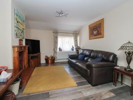 A living room with a brown leather sofa a wooden fireplace a television and a yellow rug at 4 Queen Street in Withernsea