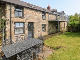 An outdoor area with a stone house and seating at The Cottage in St. Ives