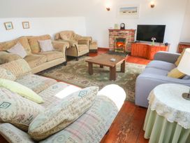 A living room with sofas and a television at The Cottage in St. Ives