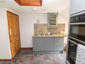A kitchen with cabinets and appliances at The Cottage in St. Ives