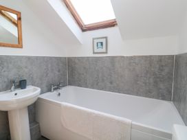 A bathroom with a bath tub and sink at The Cottage in St. Ives