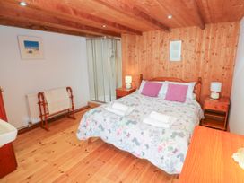 A bedroom with a bed and shower at The Cottage in St. Ives