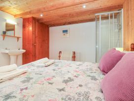 A bedroom with a bed and a sink at The Cottage in St. Ives