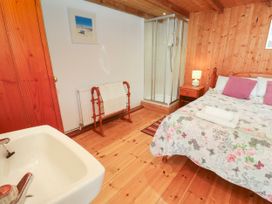 A bedroom with a bed and a shower at The Cottage in St. Ives