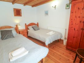 A bedroom with two beds and wooden furniture at The Cottage in St. Ives