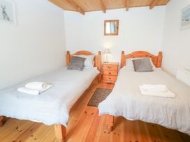 A bedroom with two single beds and a bedside table at The Cottage in St. Ives