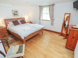 A bedroom with a bed and wooden furniture at The Cottage in St. Ives