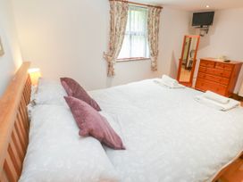 A bedroom with a bed and dresser at The Cottage in St. Ives