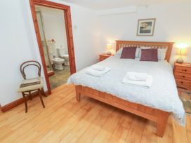 A bedroom with a bed and bathroom access at The Cottage in St. Ives
