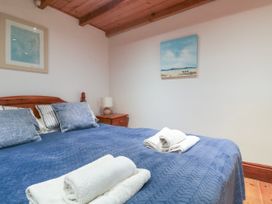 A bedroom with a bed and towels at The Cottage in St. Ives