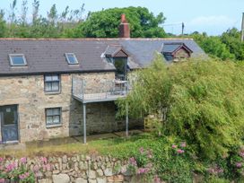 A stone building with a balcony and flowers at The Cottage in St. Ives