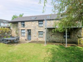 An outdoor area with a stone house and a metal table at The Cottage in St. Ives