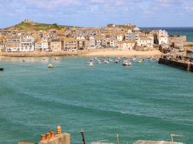 A view of buildings and boats in a harbor at The Cottage in St. Ives
