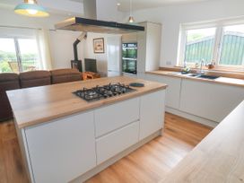 A kitchen with a gas stove and refrigerator at Swallows Nest in St. Ives