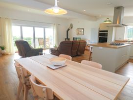 An open plan living area with a dining table and sofa at Swallows Nest in St. Ives
