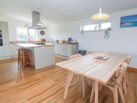 A kitchen with a dining table and appliances at Swallows Nest in St. Ives