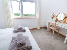 A bedroom with a bed and a desk with a mirror at Swallows Nest in St. Ives