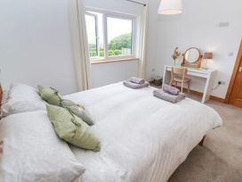 A bedroom with a bed, desk and chair at Swallows Nest in St. Ives