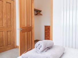 A bedroom with a towel and dresser at Swallows Nest in St. Ives
