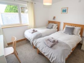 A bedroom with two twin beds and a desk at Swallows Nest in St. Ives