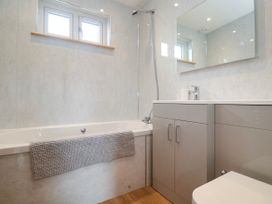A bathroom with a bath tub, sink, and toilet at Swallows Nest in St. Ives