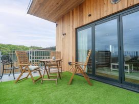 An outdoor seating area with wooden furniture at Swallows Nest in St. Ives