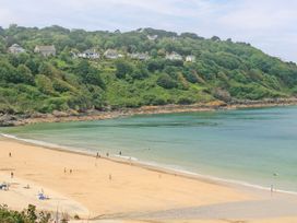 A beach with people and hills in the background at Swallows Nest in St. Ives