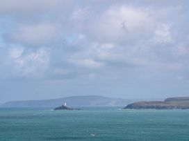 A view of an island with a lighthouse and ocean at Swallows Nest St. Ives