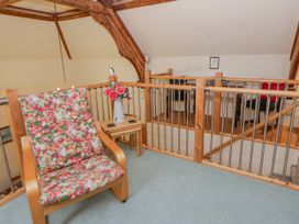 A seating area with a chair and table in a loft space at Yr Hen Ysgoldy