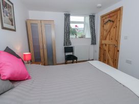 A bedroom with a bed and wardrobe at Yr Hen Ysgoldy