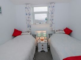 A bedroom with two beds and a nightstand at Yr Hen Ysgoldy 