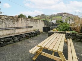 A picnic table and benches in a garden area at Yr Hen Ysgoldy