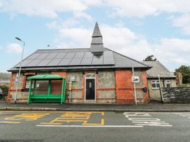 A building with solar panels and a bus stop in front at Yr Hen Ysgoldy