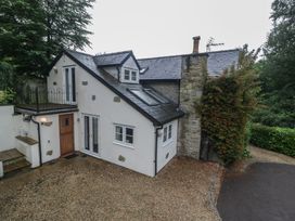 A house with a stone wall and a balcony at Wren Cottage in Ross-on-Wye