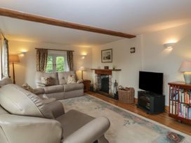 A living room with a fireplace and television at Wren Cottage in Ross-on-Wye