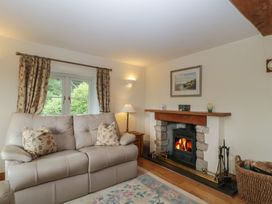 A living room with a sofa and fireplace at Wren Cottage in Ross-on-Wye