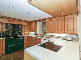A kitchen with wooden cabinets and a green oven at Wren Cottage in Ross-on-Wye