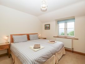 A bedroom with a bed and bedside table at Wren Cottage in Ross-on-Wye