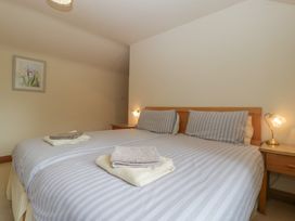 A bedroom with striped bed linens and towels at Wren Cottage in Ross-on-Wye