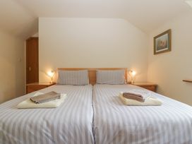 A bedroom with a bed and towels at Wren Cottage in Ross-on-Wye