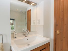 A bathroom with a washbasin and mirror at Wren Cottage in Ross-on-Wye