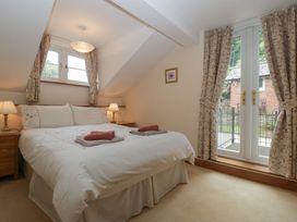A bedroom with a bed and curtains at Wren Cottage in Ross-on-Wye